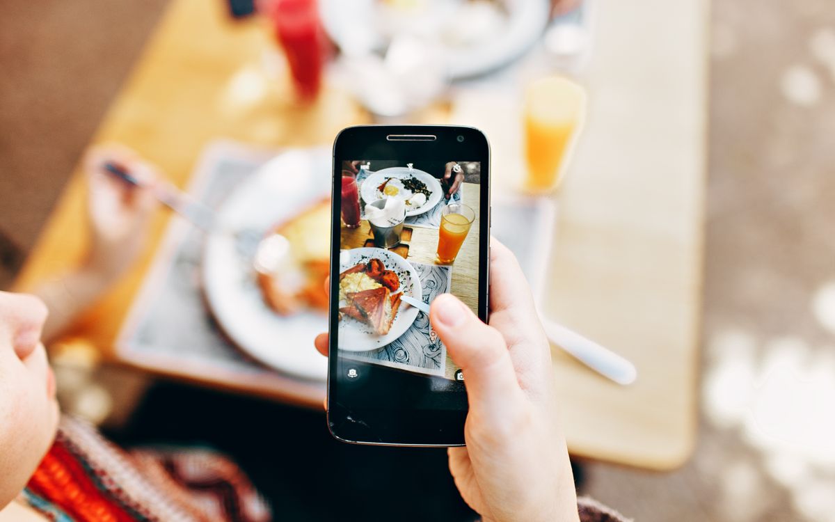 A diner photographing a brunch spread with a smartphone